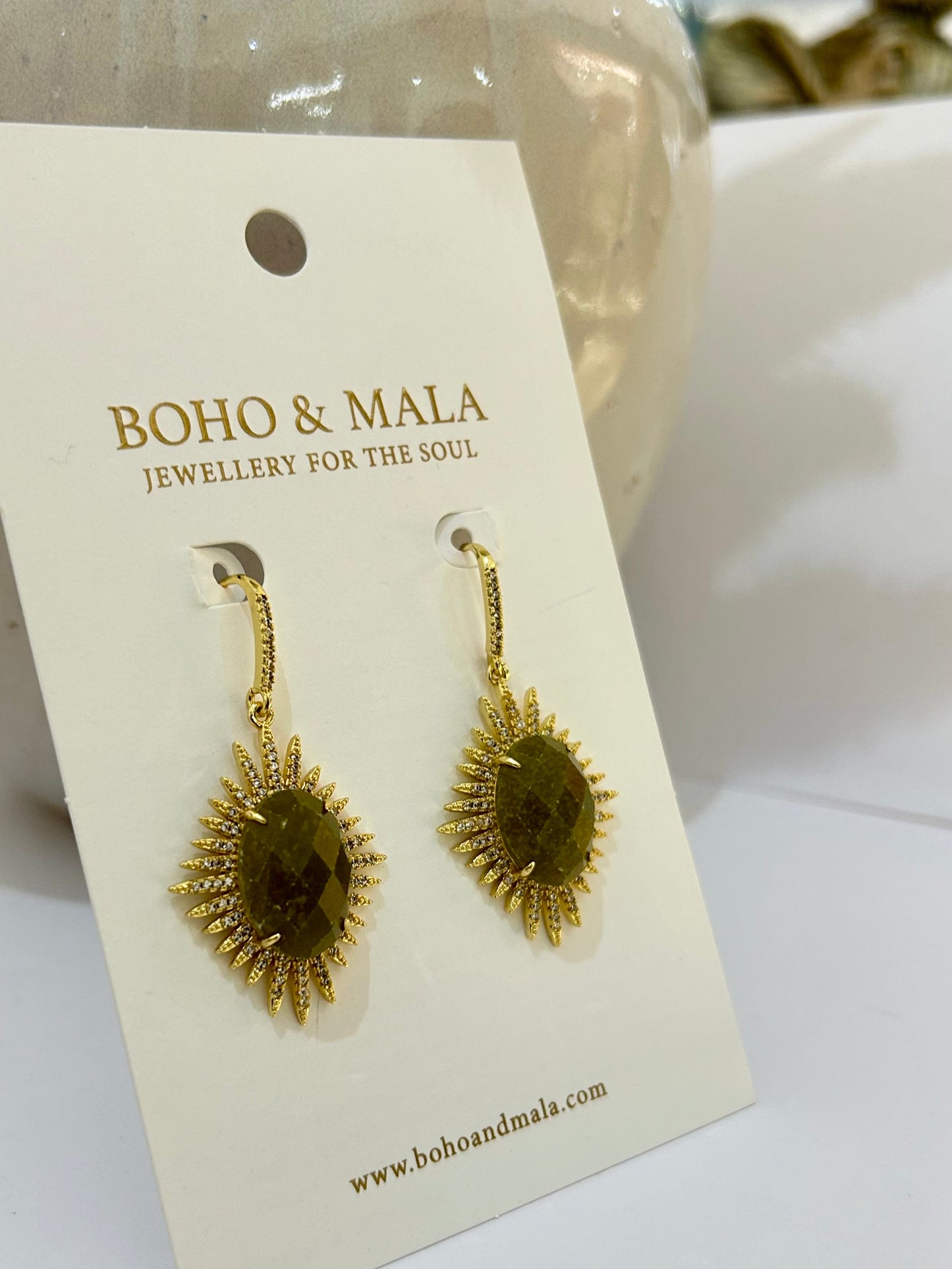 
                  
                    Gold earrings on a BOHO & MALA branded card
                  
                