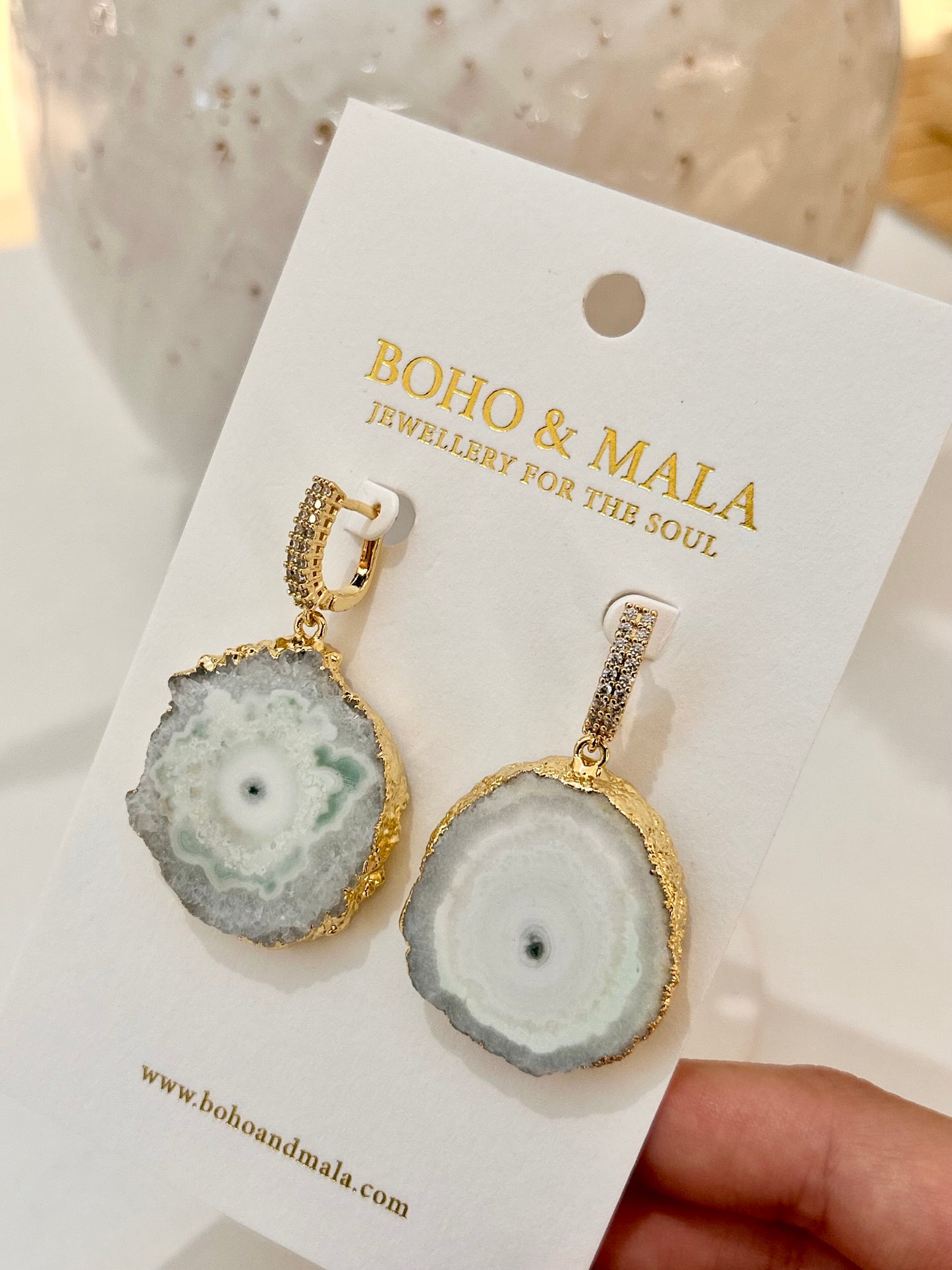 
                  
                    Geode-style earrings on a 'Boho & Mala' branded card
                  
                