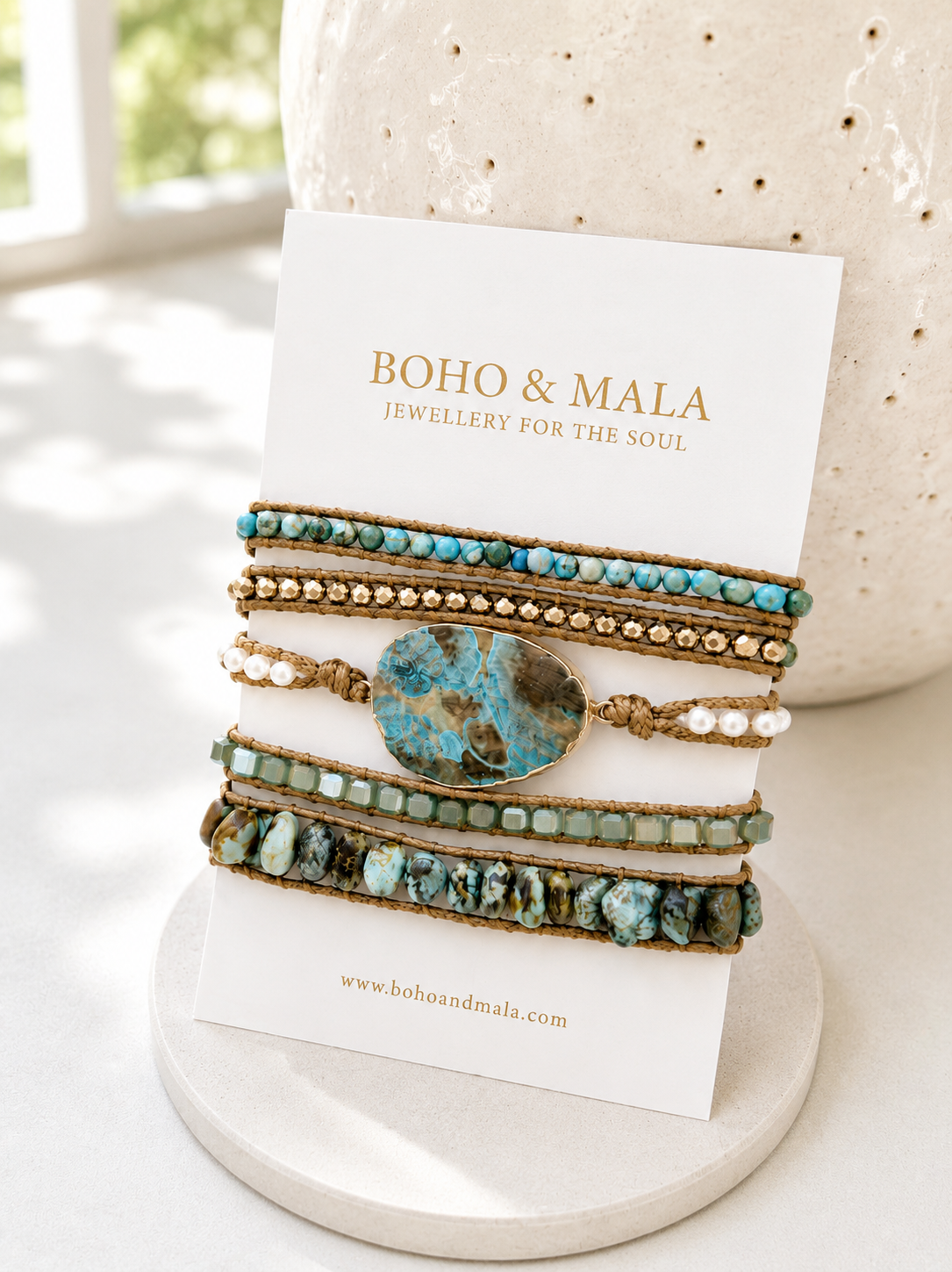 Set of bracelets with turquoise stones on a 'Boho & Mala' branded card.