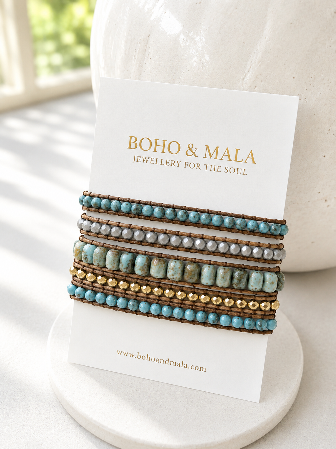 Set of beaded African turquoise wrap bracelets on a 'Boho & Mala' branded card with a blurred natural background