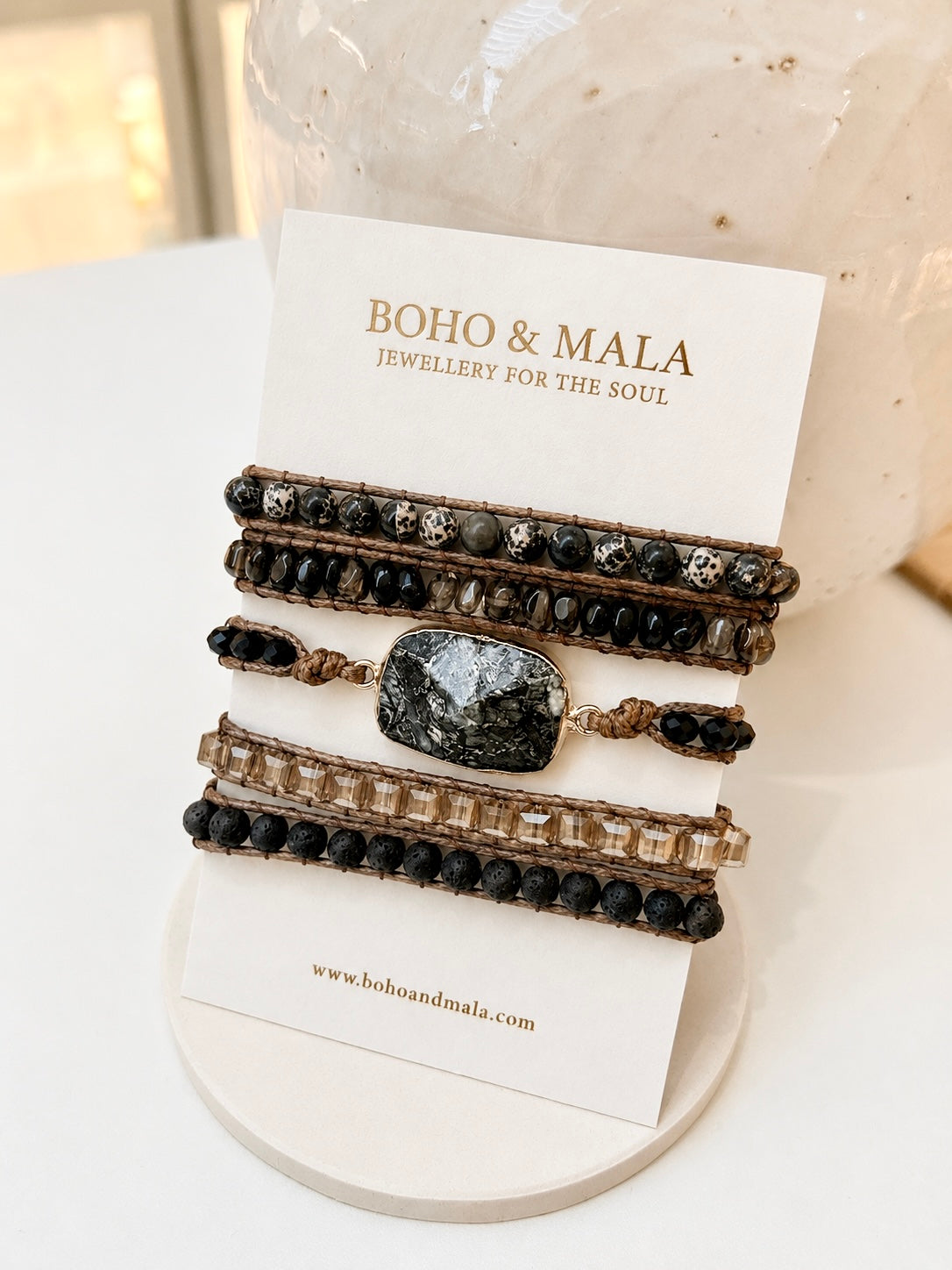 bohemian-style beaded natural stone bracelets from Boho & Mala, featuring black onyx and Dalmatian jasper displayed  on a white card stand.