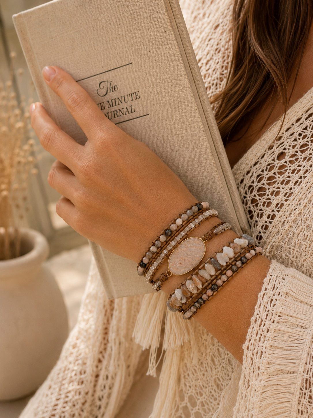 
                  
                    Person holding a beige notebook with 'The 5-Minute Journal' and wearing blush agate wrap bracelets.
                  
                