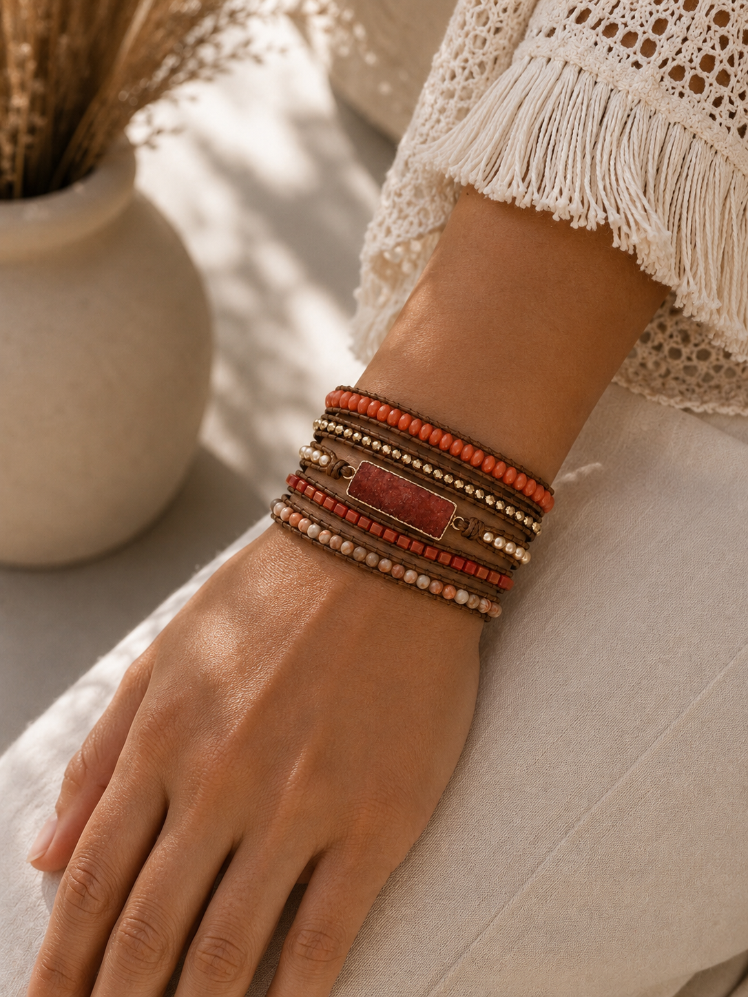 
                  
                    Close-up of a wrist wearing a coral druzy wrap bracelets with a neutral background
                  
                