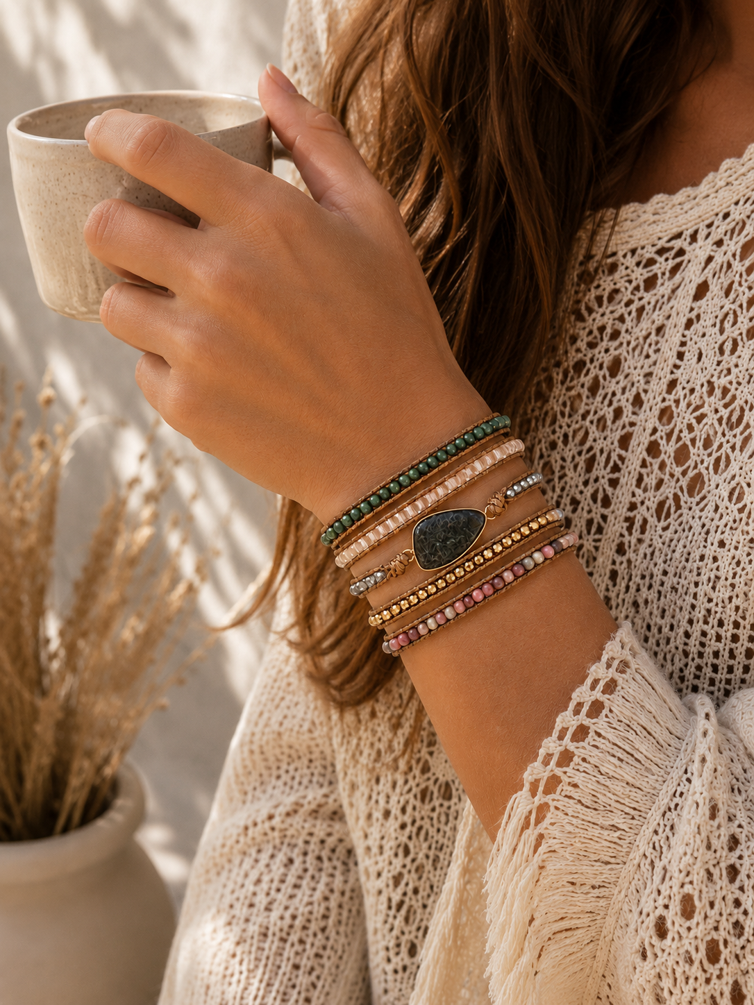 
                  
                    Person holding a mug with kambaba jasper mixed wrap bracelets on wrist, wearing a textured beige top.
                  
                