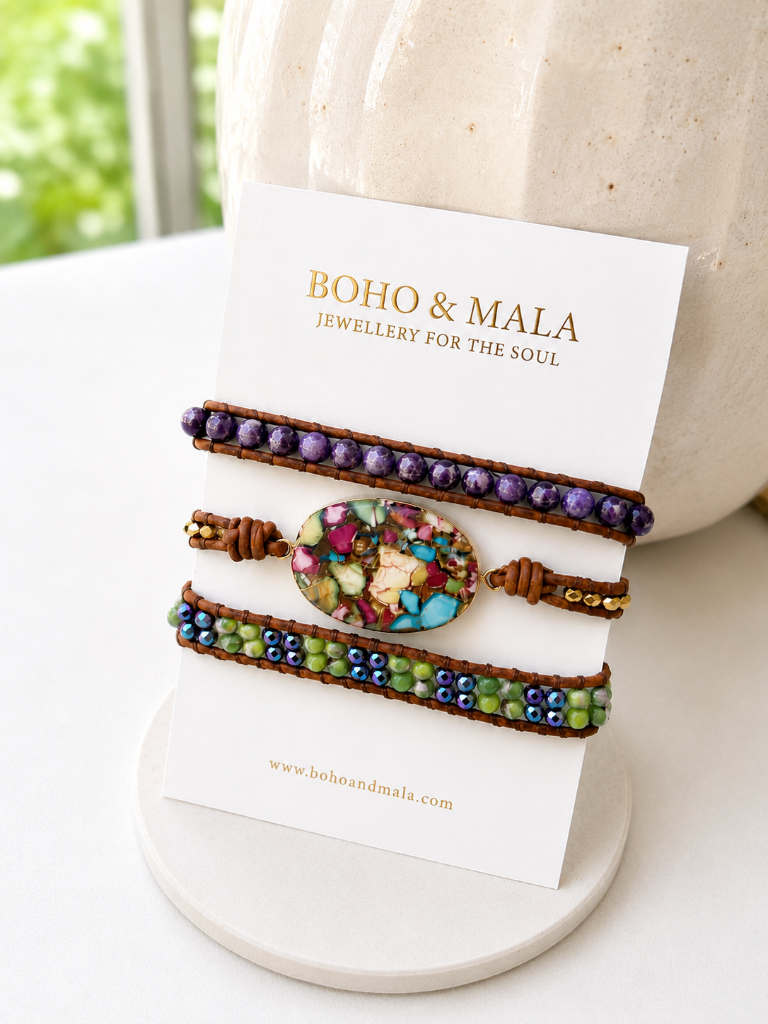 Three beaded bracelets on a 'Boho & Mala' branded card with a blurred natural background. 