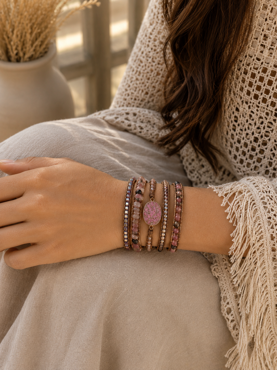 
                  
                    Person wearing wrap pink rhodonite mixed bracelets on a neutral background
                  
                