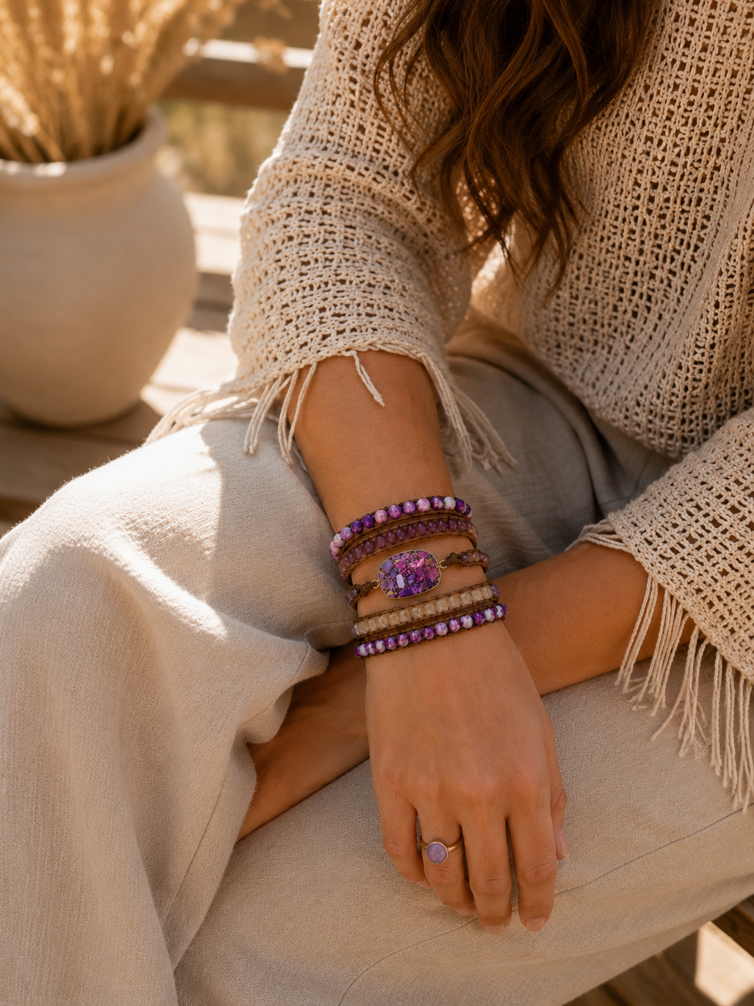 
                  
                    Person wearing amesthsty mixed wrap bracelets and a ring with a scenic background
                  
                
