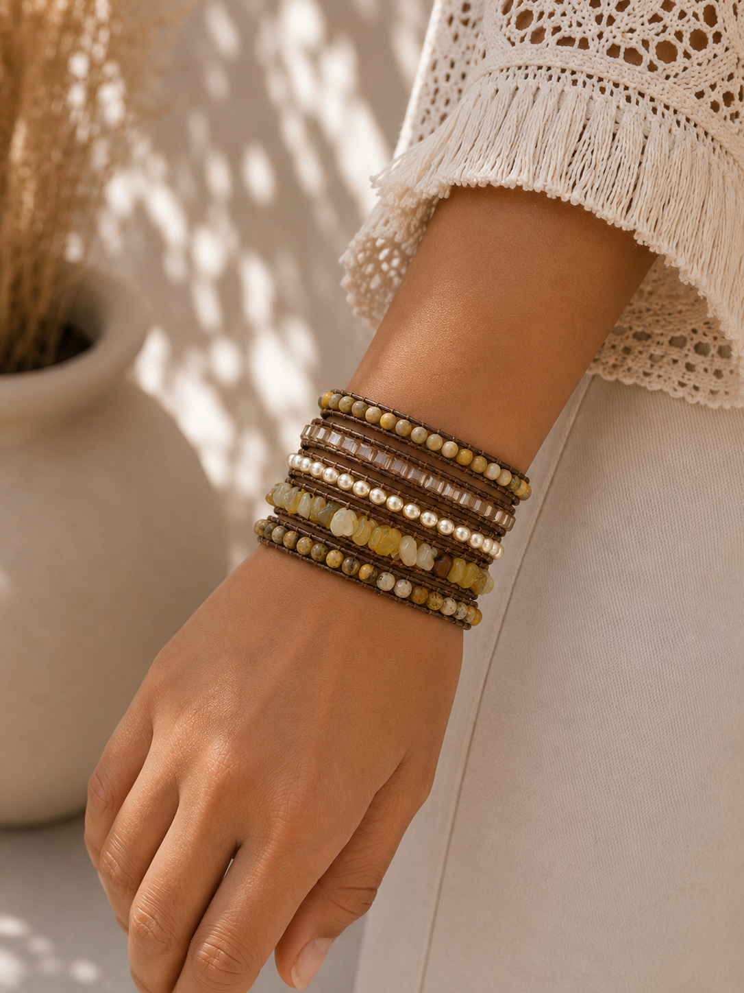 
                  
                    Hand wearing yellow jade beaded bracelets with a neutral background
                  
                