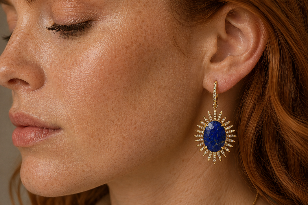 Boho & Mala gold dangle earrings with oval blue lapis lazuli stones, shown both on a white display card and worn on a model's ear.