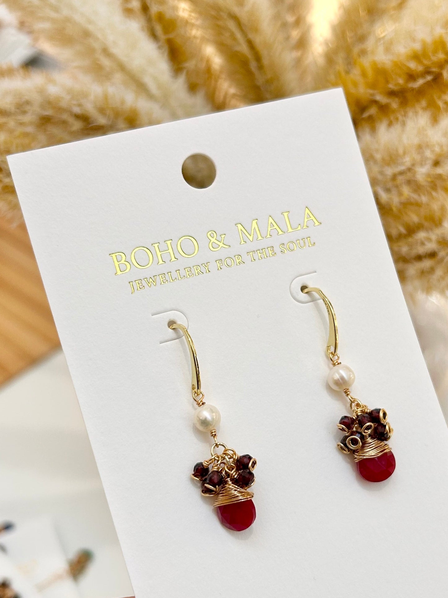 
                  
                    Pair of earrings on a BOHO & MALA branded card with a blurred background
                  
                