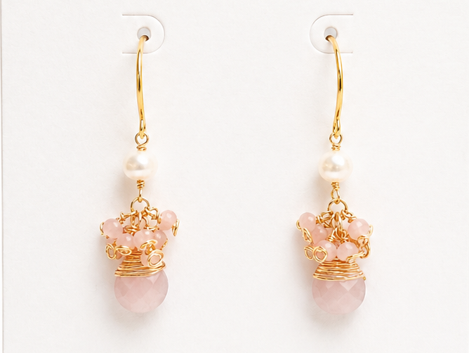 Pair of gold earrings with pink stones on a BOHO & MALA branded card.