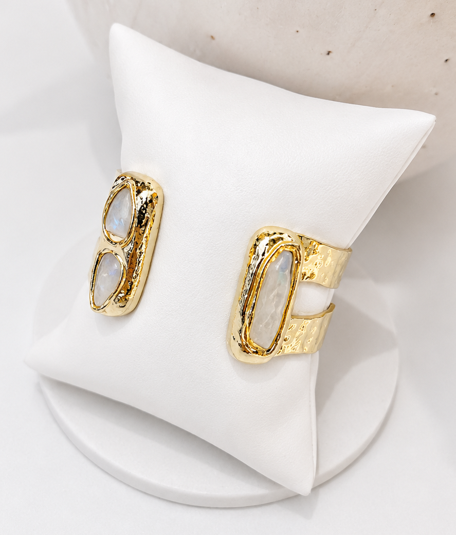 
                  
                    Gold and freshwater pearl bangle  on a white triangle stand with a neutral background
                  
                